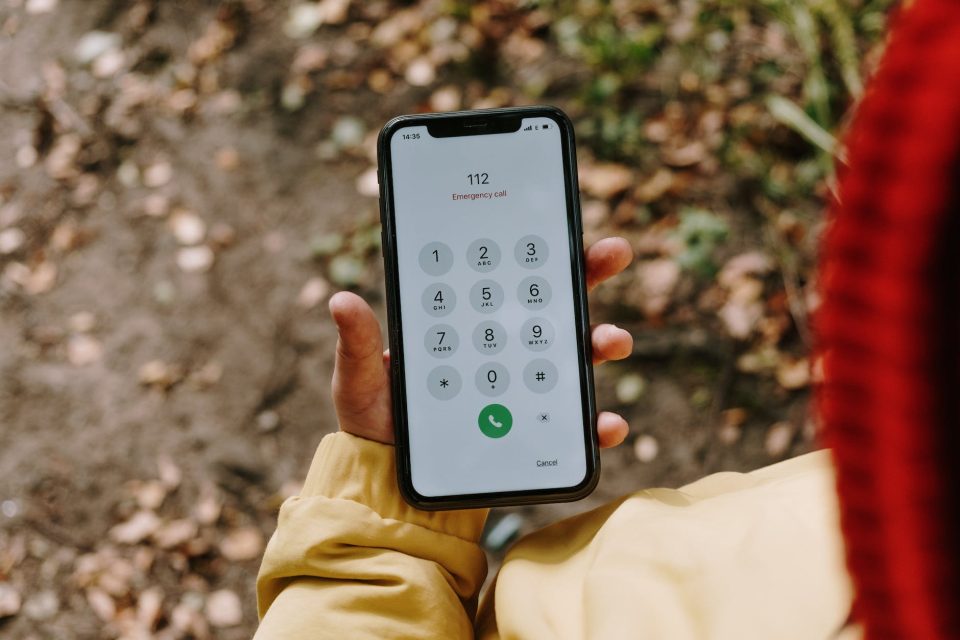 hand holding a smartphone with an emergency number dialed