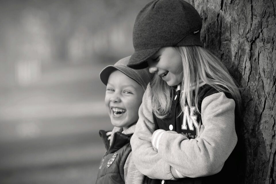 boy and girl leaning on tree