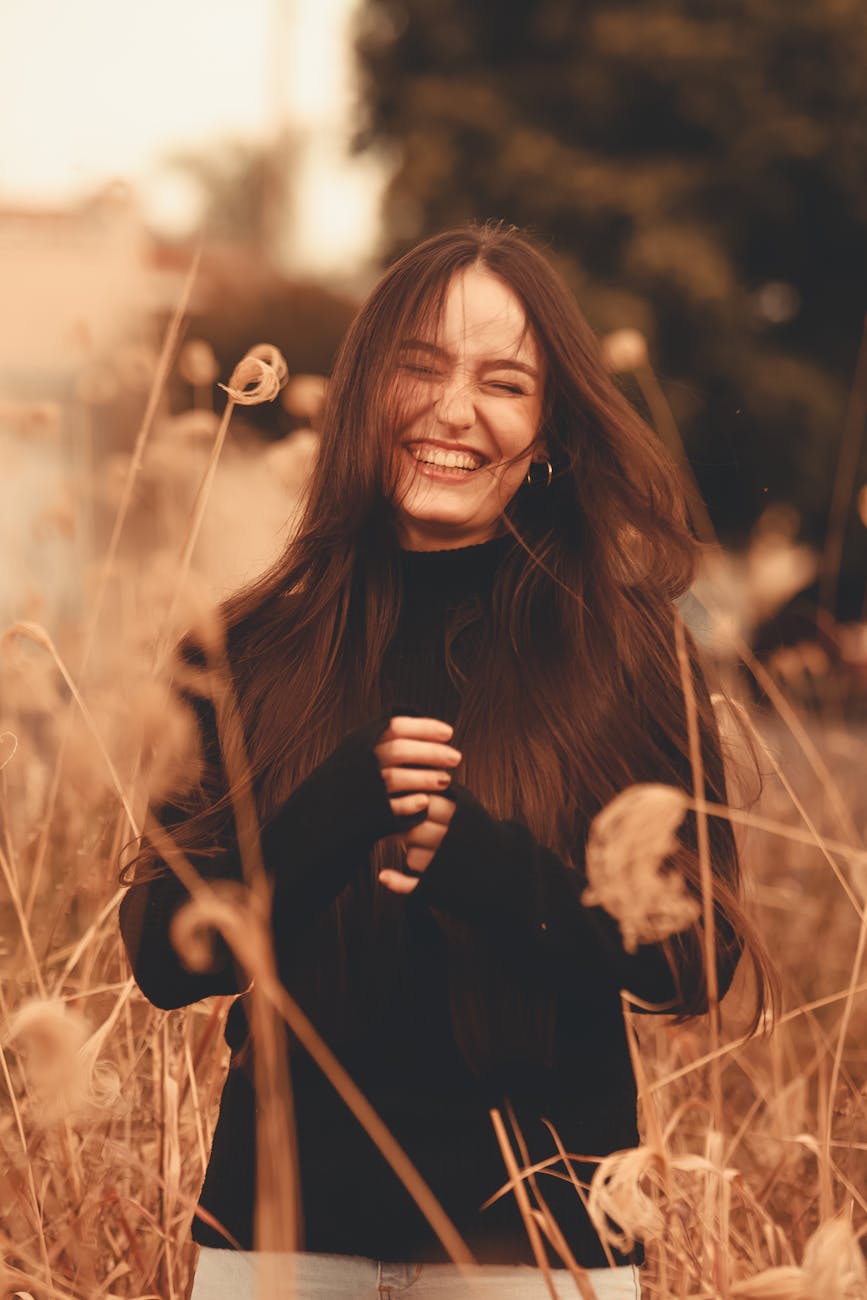 woman standing near grass while laughing