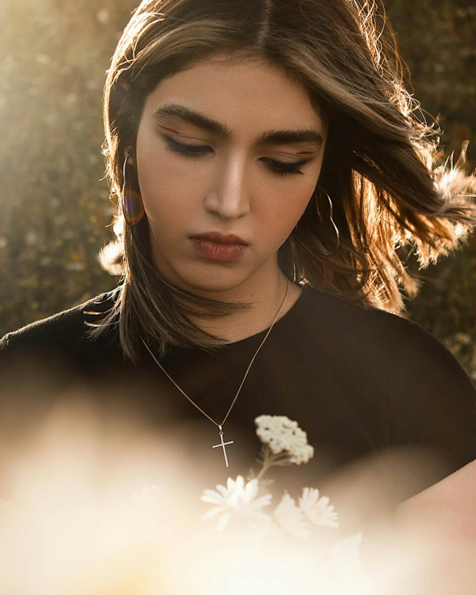 a woman with long hair holding flowers