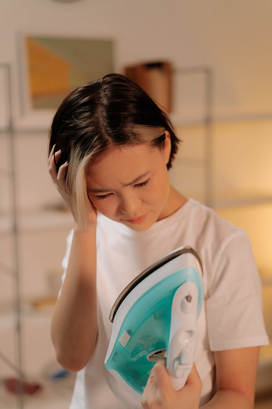 upset woman holding flat iron