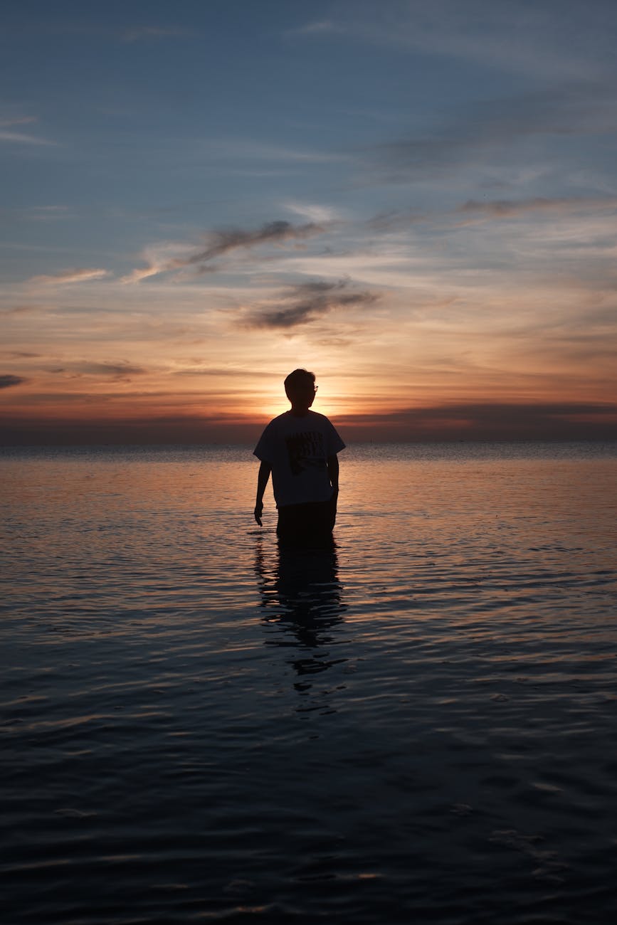 silhouette of a person at sunset by the sea
