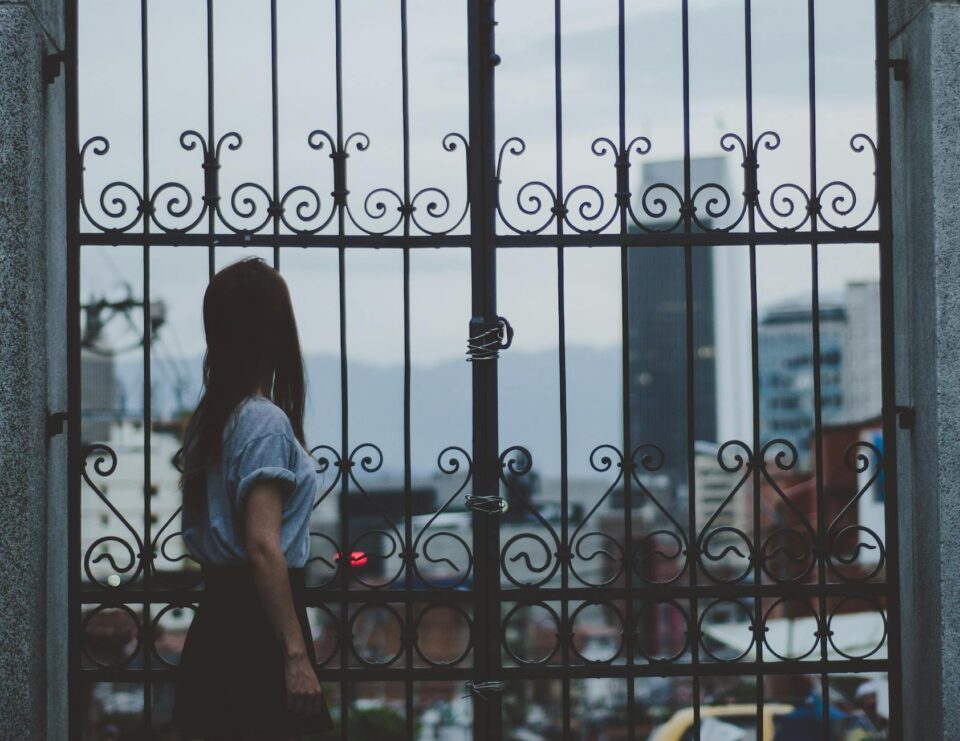 woman standing beside gate