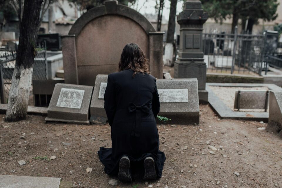 woman in black dress kneeling on brown soil