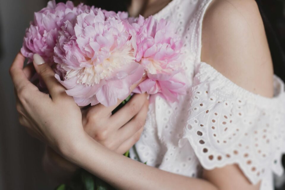 woman holding pink flowers