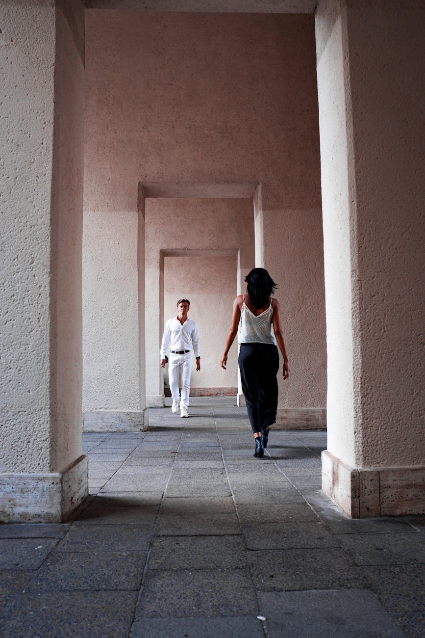 two women walking through an archway in a building