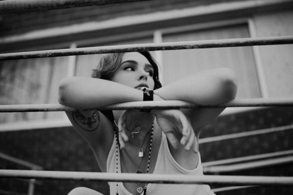 a grayscale of a tattooed woman in a tank top