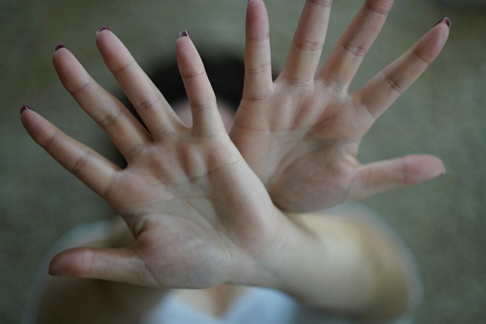 close up photograph of a person s crossed hands