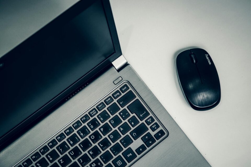 opened silver laptop and black computer mouse