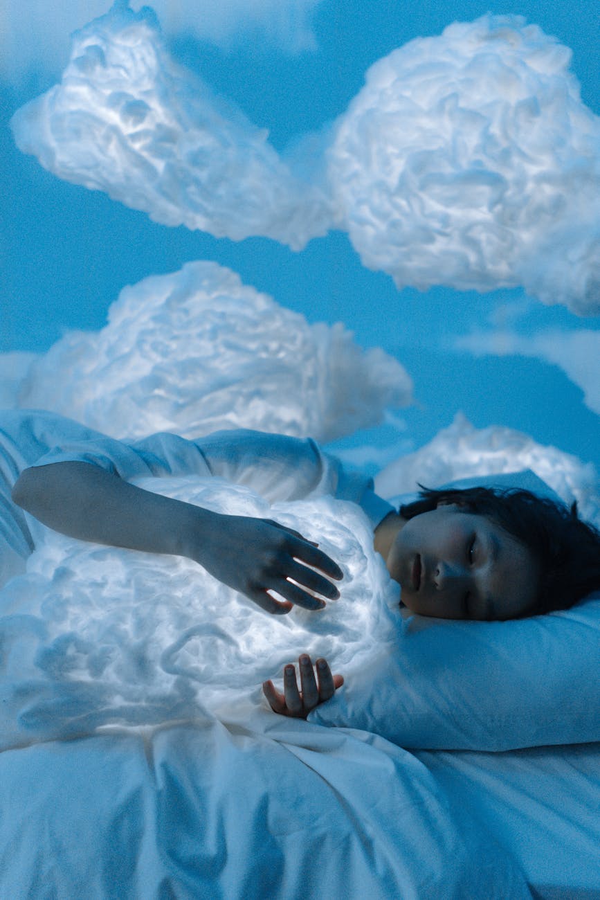 a woman sleeping on the bed while hugging a cloud pillow