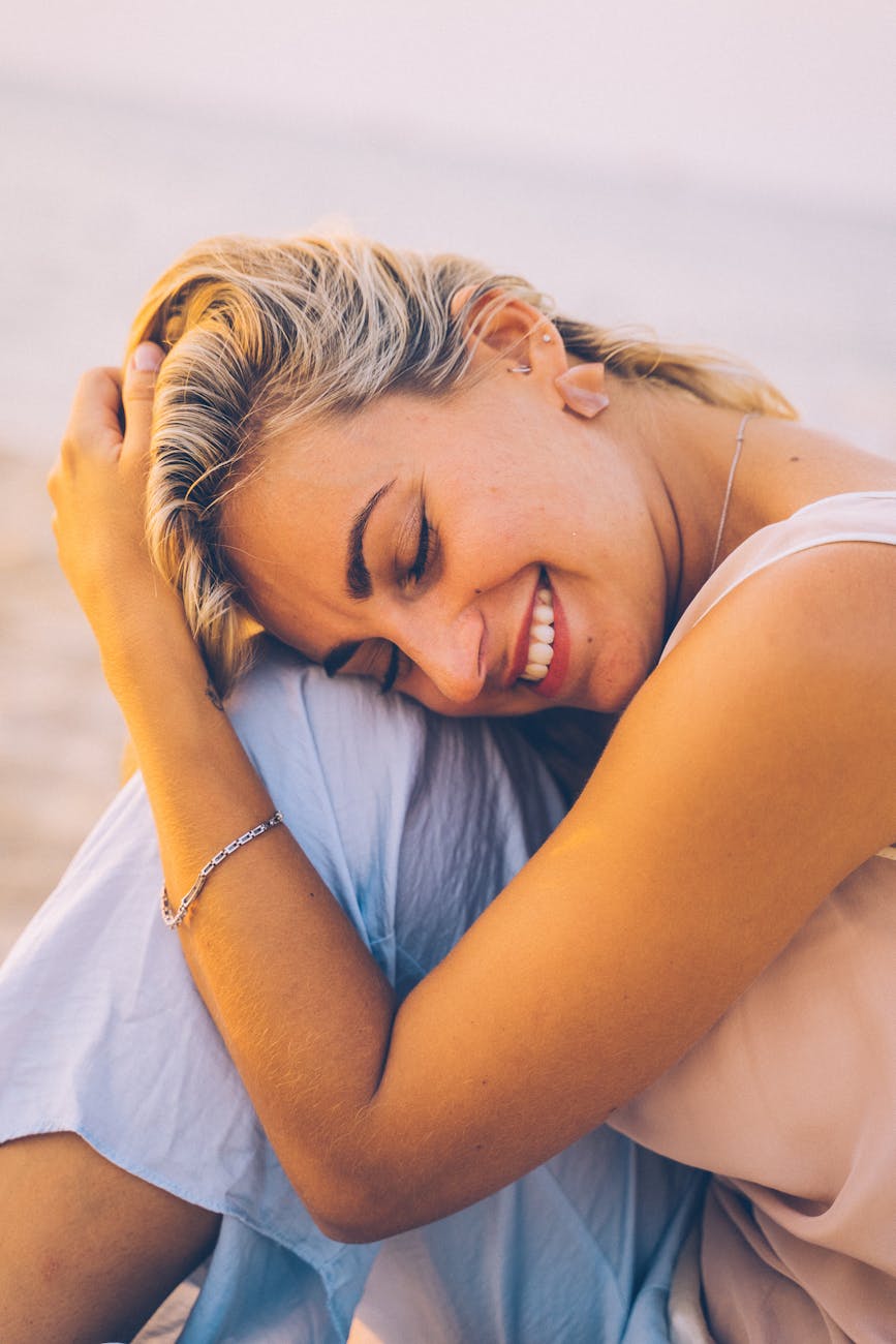 close up shot of a woman smiling with her eyes closed