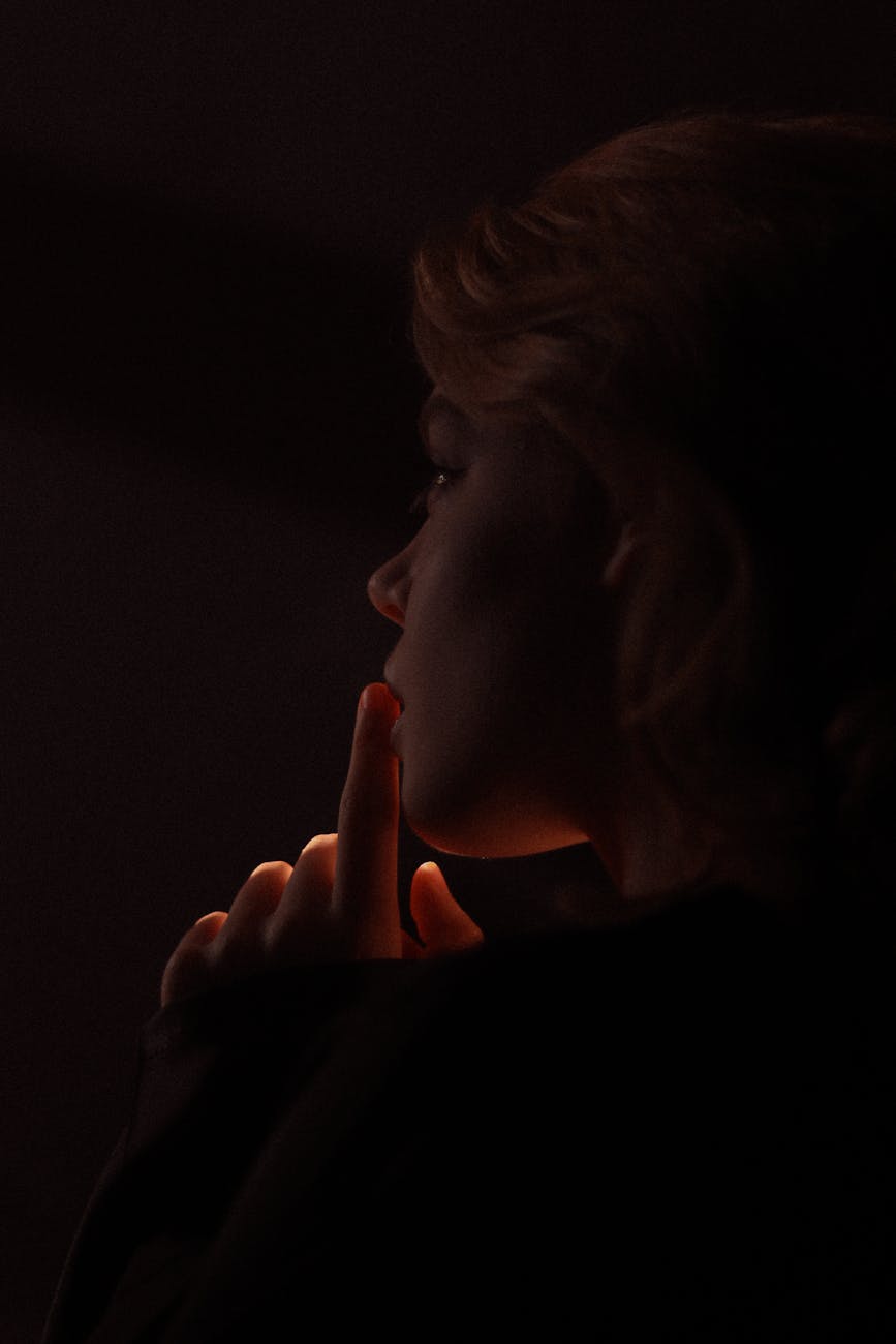 woman doing a hand sign in the dark
