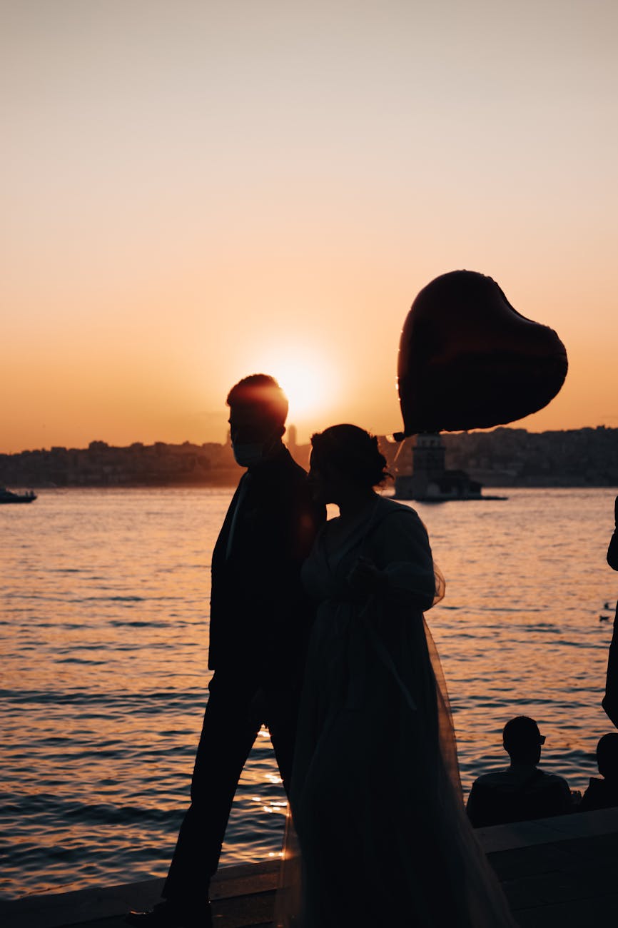 a couple walking on the bay during sunset