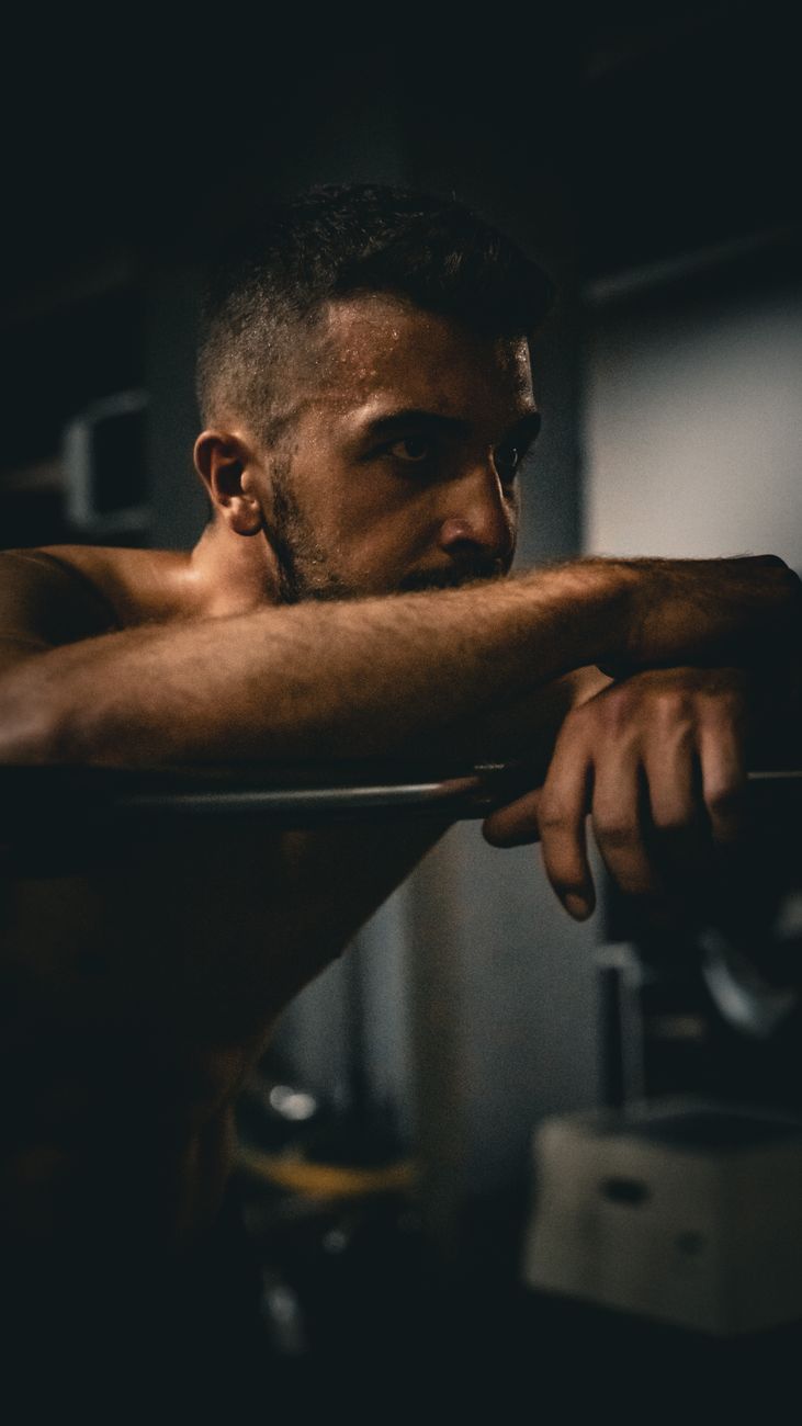 man leaning on bat at gym