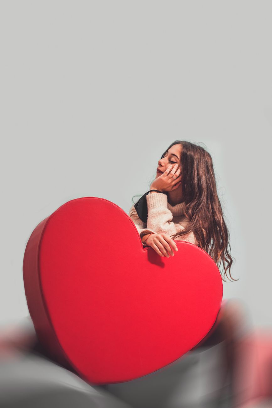 woman holding a red heart shaped box