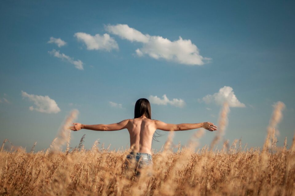 shirtless person standing on the field of crops