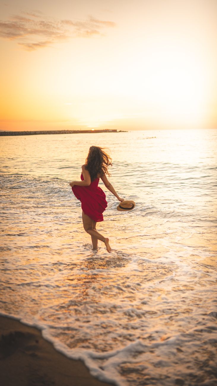unrecognizable woman running in waving sea